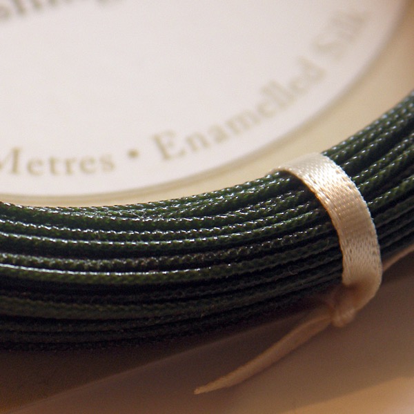 Close up detail of a braided silk fishing line in a mere green colour.